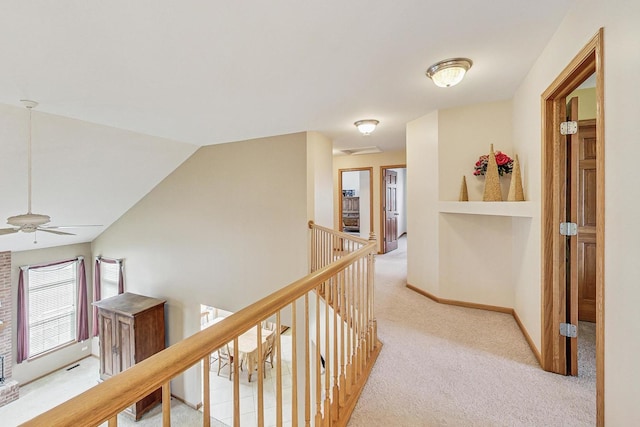 hallway with lofted ceiling and light carpet