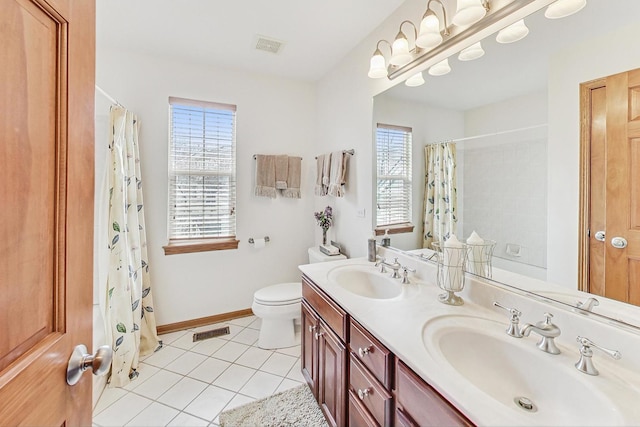 bathroom with tile patterned flooring, vanity, plenty of natural light, and toilet