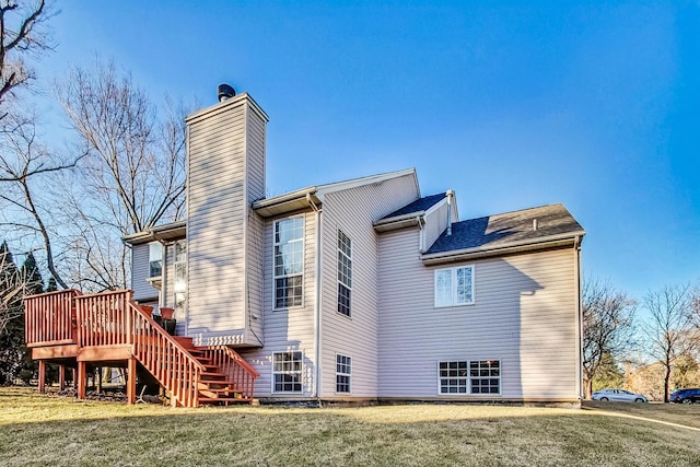 rear view of property featuring a deck and a lawn