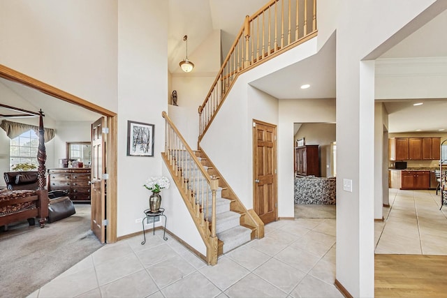 stairway featuring a high ceiling and carpet flooring