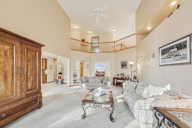 carpeted living room with ceiling fan and a high ceiling