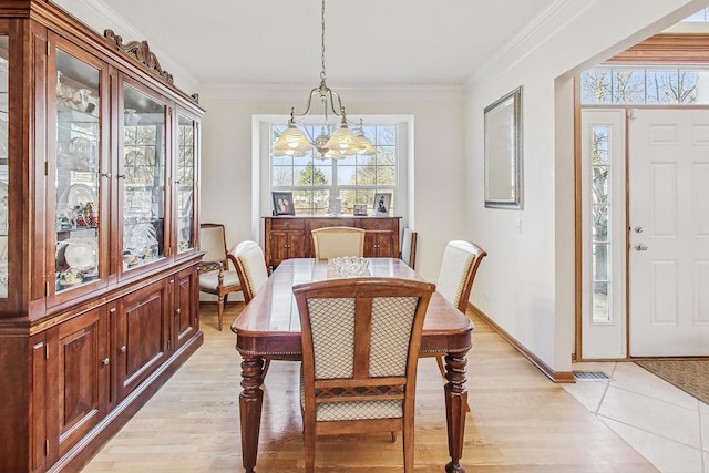 dining area with ornamental molding and light wood-type flooring