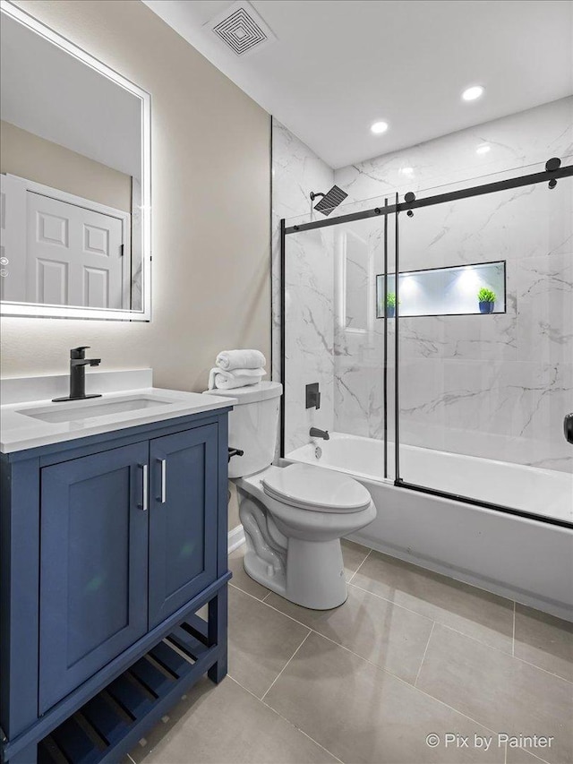 full bathroom featuring enclosed tub / shower combo, vanity, tile patterned floors, and toilet