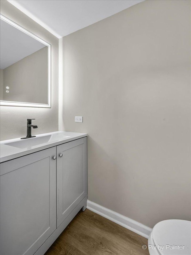 bathroom featuring vanity, hardwood / wood-style floors, and toilet