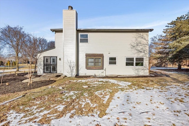 view of snow covered rear of property