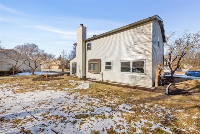 view of snow covered back of property