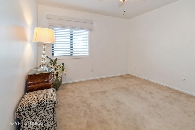 living area with ceiling fan, baseboards, and carpet flooring