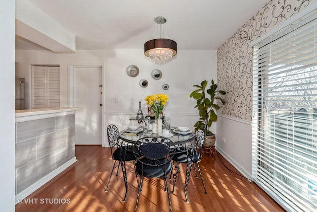 dining room featuring wainscoting, wood finished floors, and an inviting chandelier