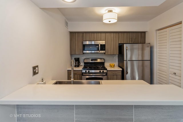 kitchen with tasteful backsplash, visible vents, modern cabinets, appliances with stainless steel finishes, and light countertops