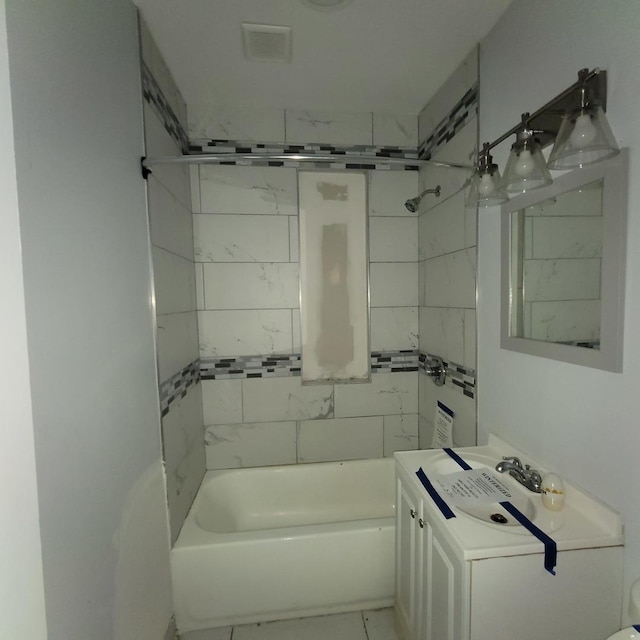 bathroom featuring tiled shower / bath combo and vanity