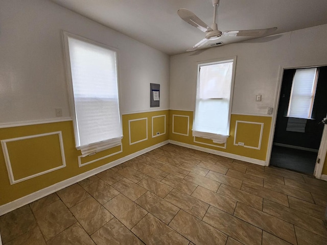 tiled empty room featuring ceiling fan