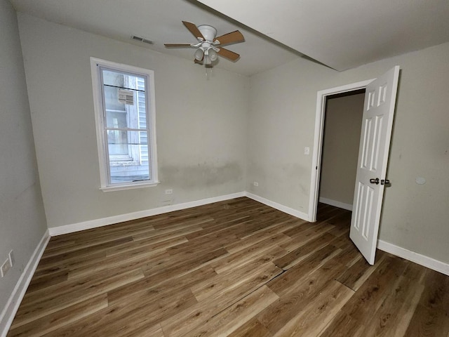 unfurnished room with dark wood-type flooring and ceiling fan