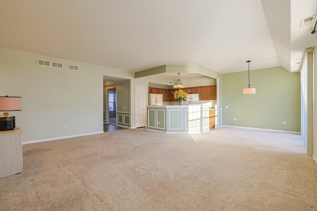 unfurnished living room featuring vaulted ceiling and light carpet