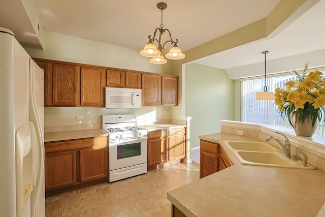 kitchen featuring hanging light fixtures, white appliances, a notable chandelier, and sink