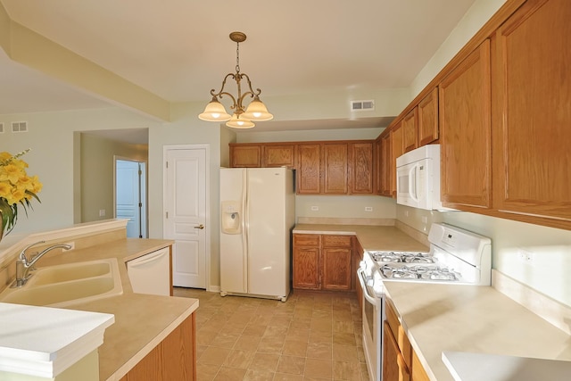 kitchen with white appliances, a chandelier, sink, and hanging light fixtures