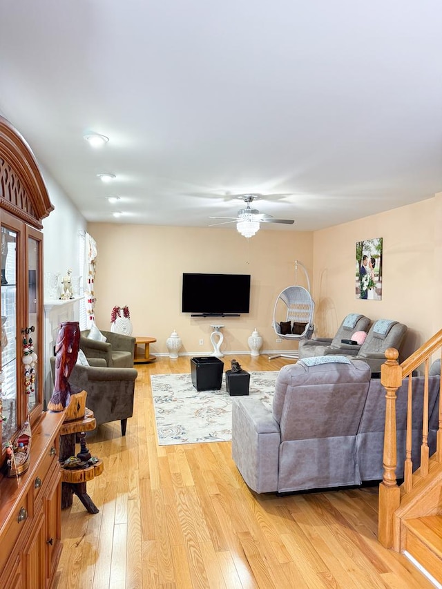 living room featuring ceiling fan and light hardwood / wood-style flooring