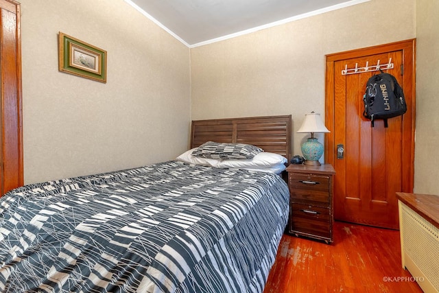 bedroom with crown molding and dark hardwood / wood-style flooring