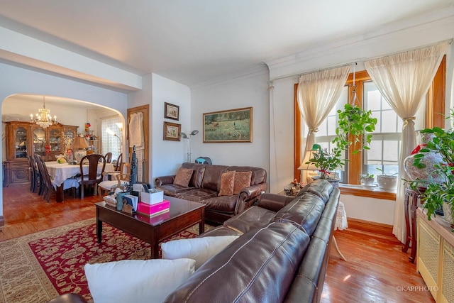 living room with an inviting chandelier, crown molding, and hardwood / wood-style floors