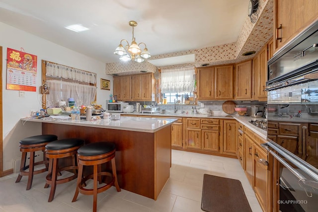 kitchen with a breakfast bar, decorative light fixtures, a center island, stainless steel appliances, and backsplash