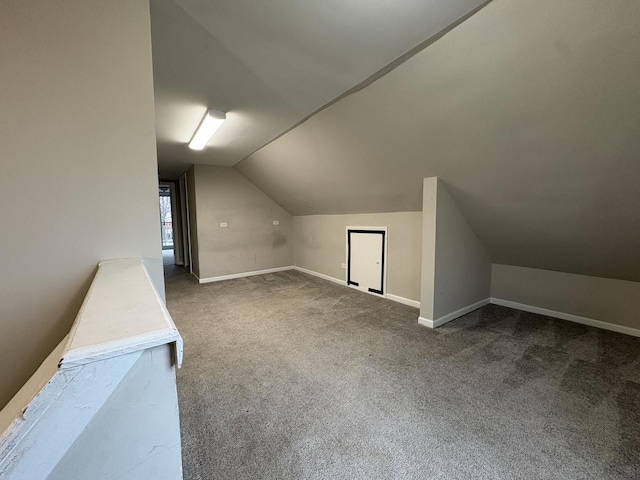 additional living space featuring vaulted ceiling and carpet