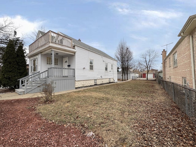 view of home's exterior with a yard and a balcony