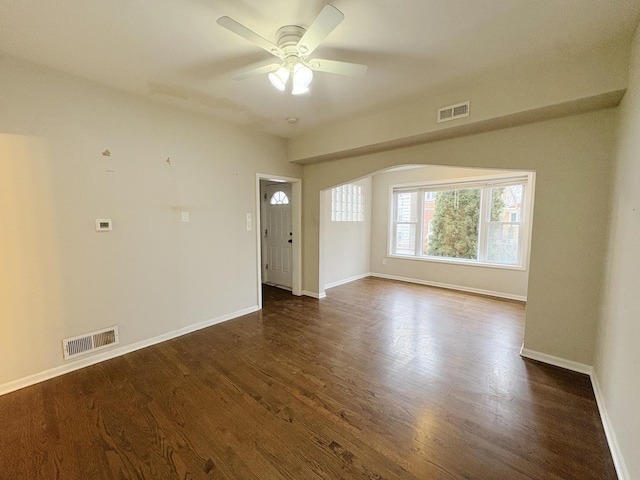 empty room with ceiling fan and dark hardwood / wood-style flooring