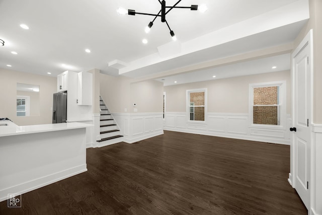 unfurnished living room with dark hardwood / wood-style floors and a notable chandelier