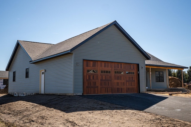 view of front of home featuring a shingled roof, aphalt driveway, and a garage