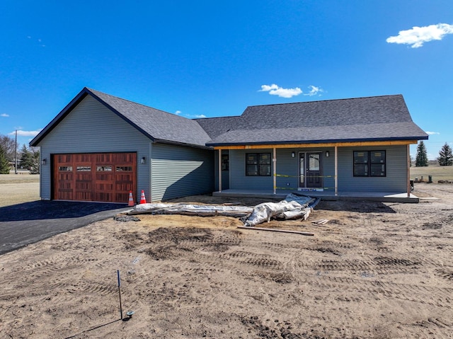 view of front of home featuring an attached garage, aphalt driveway, a porch, and a shingled roof