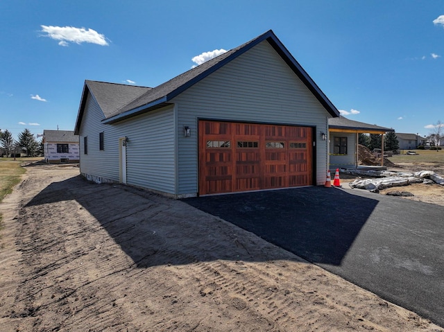 view of side of home with driveway and a garage
