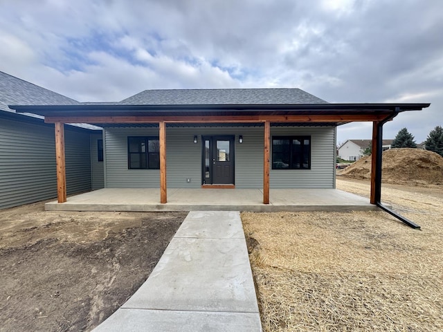 exterior space with a shingled roof and covered porch
