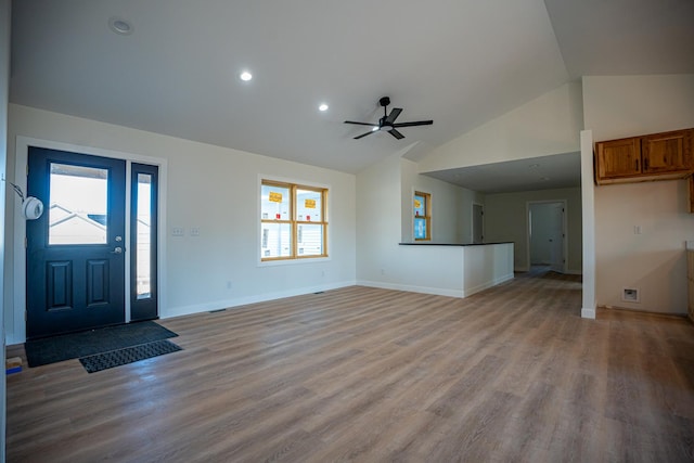 unfurnished living room featuring high vaulted ceiling, light wood-style floors, baseboards, and a ceiling fan