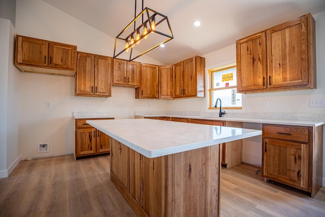 kitchen featuring lofted ceiling, brown cabinetry, and a sink