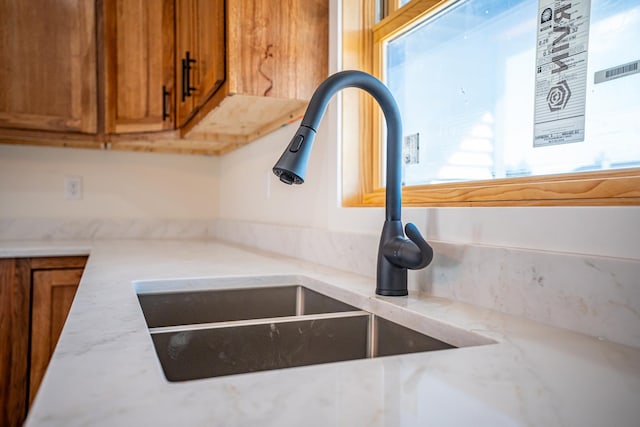 details with light countertops, brown cabinetry, and a sink