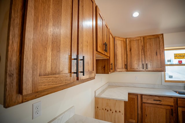 kitchen featuring brown cabinets, light countertops, and a sink