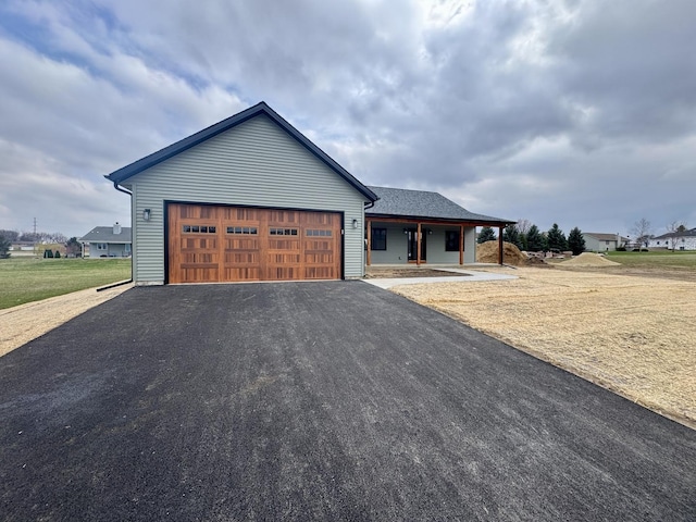view of front of property featuring an attached garage, aphalt driveway, and a porch