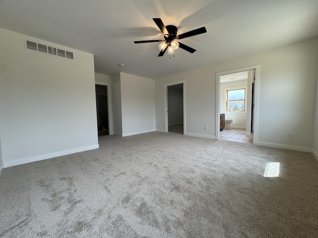 unfurnished bedroom with a spacious closet, carpet, visible vents, and baseboards