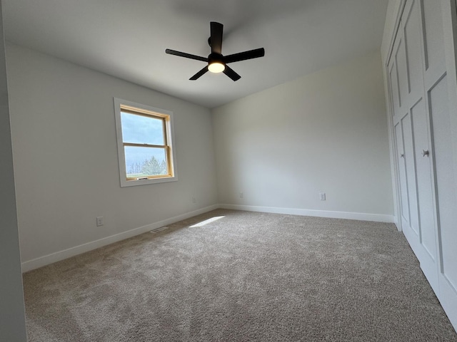 unfurnished bedroom featuring carpet floors, a ceiling fan, and baseboards