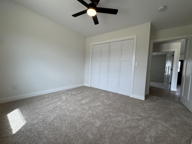 unfurnished bedroom featuring baseboards, carpet flooring, and a closet