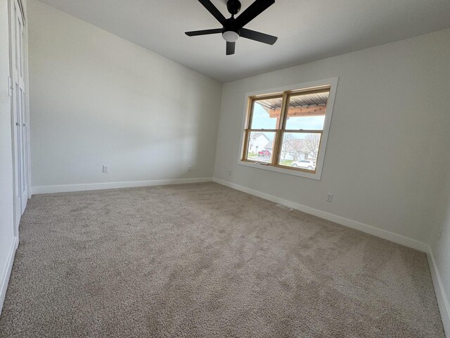 unfurnished room with carpet, baseboards, and ceiling fan