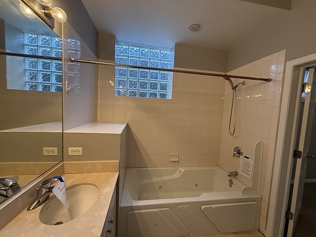 bathroom featuring tiled shower / bath combo and vanity