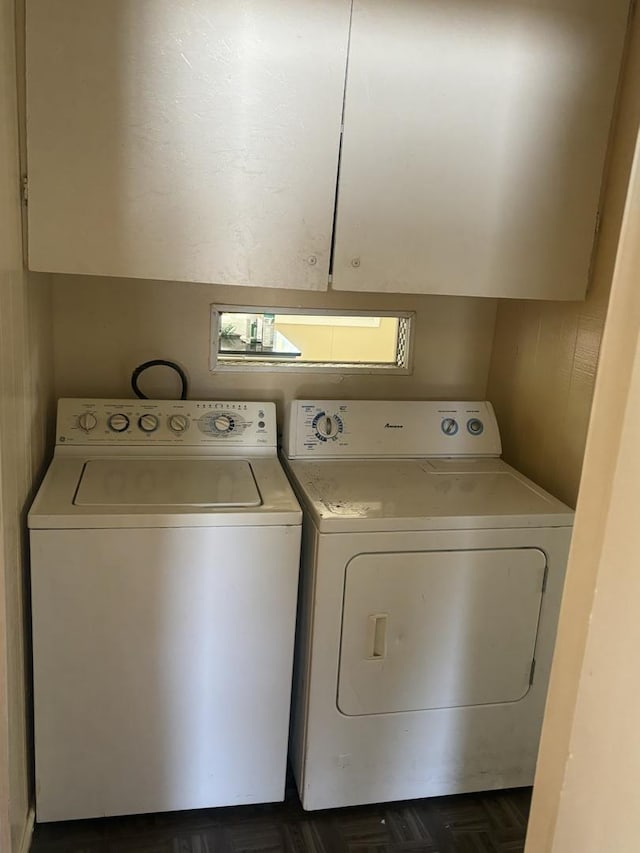 washroom with cabinets, washing machine and clothes dryer, and dark parquet floors