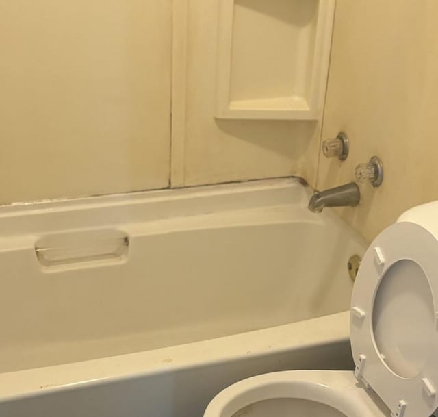 bathroom featuring toilet and tub / shower combination