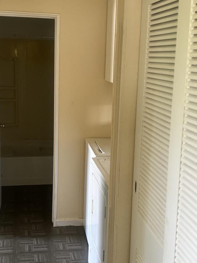 clothes washing area featuring dark parquet floors and washer and dryer