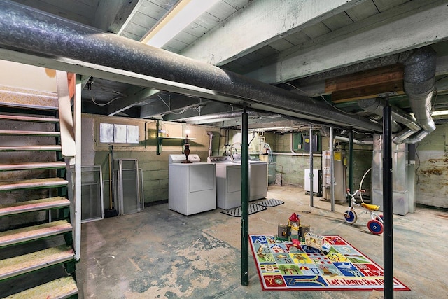 basement featuring heating unit, washing machine and clothes dryer, and water heater