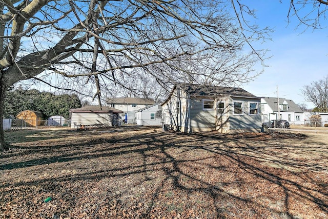 rear view of property featuring a storage shed