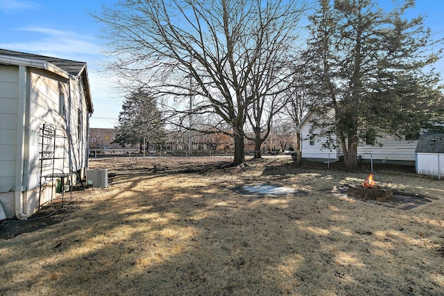 view of yard with an outdoor fire pit and central AC unit