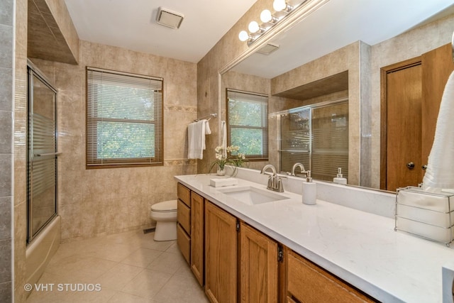 full bathroom featuring tile patterned flooring, plenty of natural light, tile walls, and toilet