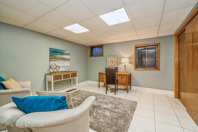 living area featuring light tile patterned flooring and a drop ceiling