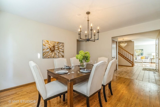 dining area with light hardwood / wood-style flooring and a chandelier